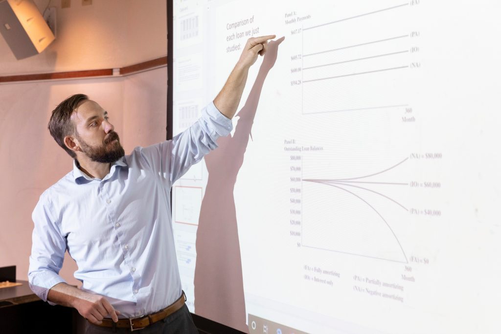 Faculty member pointing at projected image on classroom wall