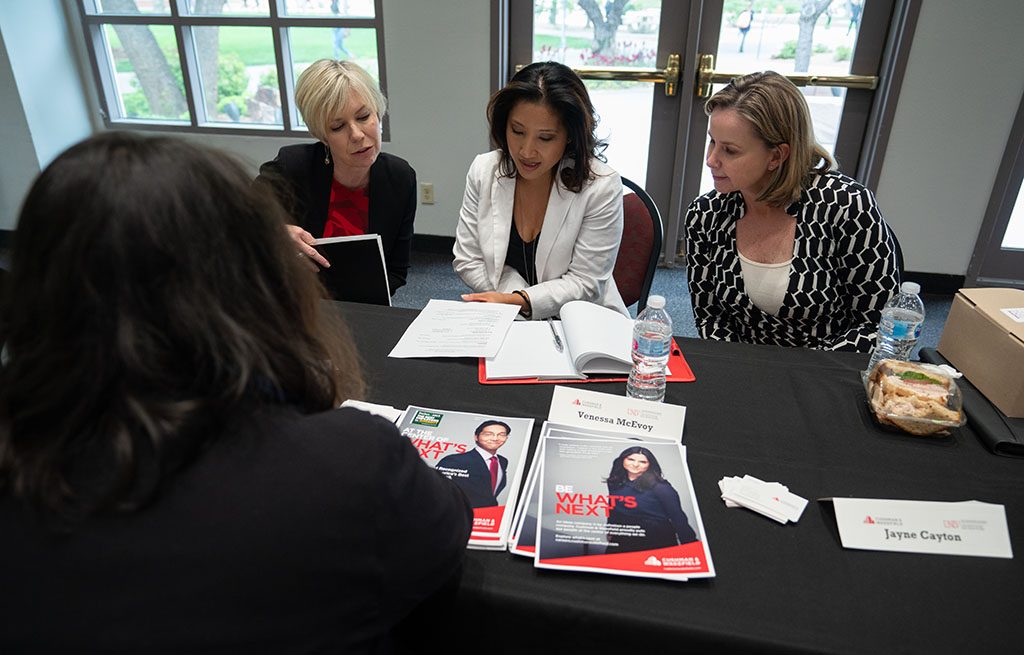 Women at a table reading a document